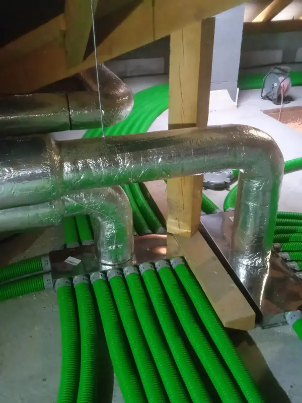 Zamontowany na strychu system rekuperacji, do którego wliczaja się podłużne, zielone rury